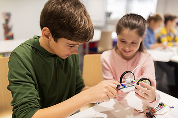 Image showing happy children building robots at robotics school