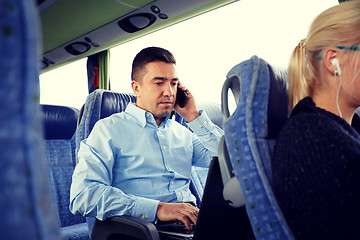 Image showing man with smartphone and laptop in travel bus