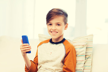 Image showing boy with smartphone texting or playing at home