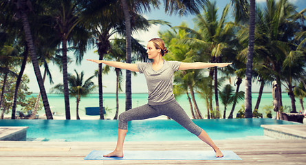 Image showing woman making yoga warrior pose over hotel resort