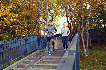 Image showing happy couple running downstairs in city