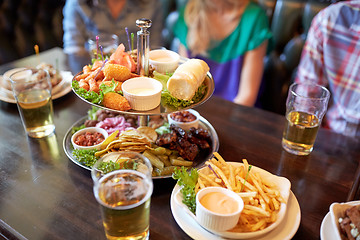 Image showing people sitting at table with food and beer at bar