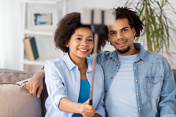 Image showing happy couple with smartphone taking selfie at home