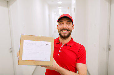 Image showing delivery man with parcel box in corridor