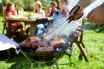 Image showing man cooking meat on barbecue grill at summer party