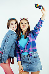 Image showing lifestyle people concept: two pretty stylish modern hipster teen girl having fun together, happy smiling making selfie 