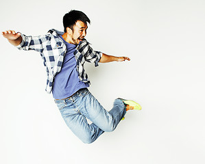 Image showing young pretty asian man jumping cheerful against white background