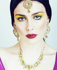 Image showing young pretty caucasian woman like indian in ethnic jewelry close up on white, bridal bright makeup