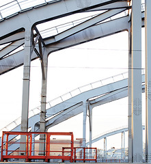 Image showing landscape with railway with trains, lot of steel rafters at sunset 