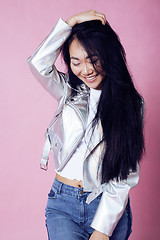 Image showing young pretty smiling asian korean girl wearing modern fashion clothers on pink background, lifestyle people concept 