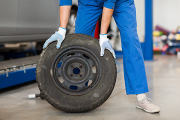 Image showing mechanic with wheel tire at car workshop