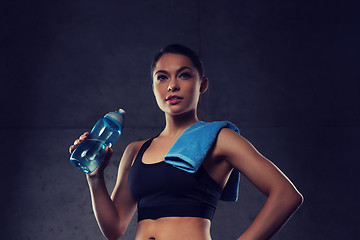 Image showing woman with towel drinking water from bottle in gym