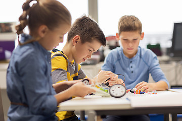 Image showing happy children building robots at robotics school