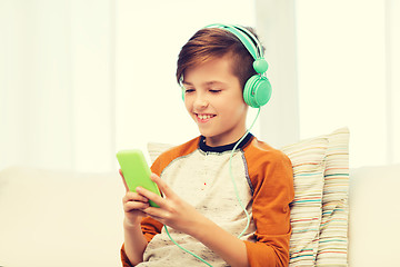 Image showing happy boy with smartphone and headphones at home