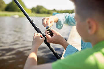 Image showing boy and grandfather with fishing rod on river