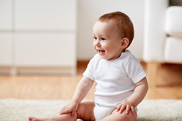 Image showing happy baby boy or girl sitting on floor at home