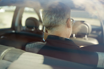 Image showing senior businessman calling on smartphone in car