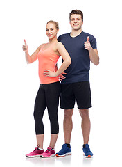 Image showing happy sportive man and woman showing thumbs up