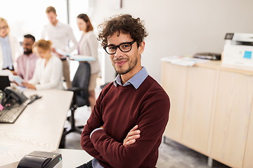 Image showing happy young man over creative team in office