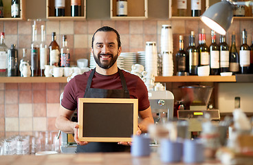 Image showing happy man or waiter with chalkboard banner at bar