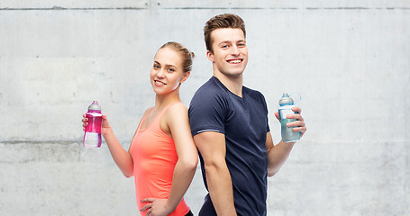 Image showing sportive man and woman with water bottles