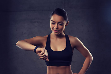 Image showing young woman with heart-rate watch in gym