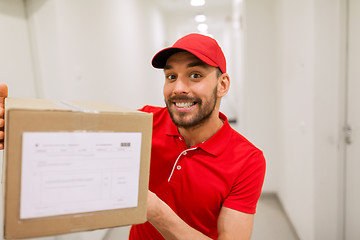 Image showing delivery man with parcel box in corridor