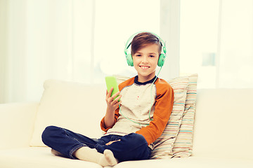 Image showing happy boy with smartphone and headphones at home