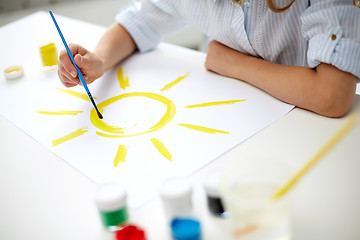 Image showing girl with brush drawing sun on paper