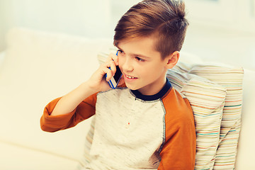 Image showing happy boy calling on smartphone at home