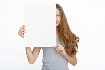 Image showing Young smiling woman show blank card or paper