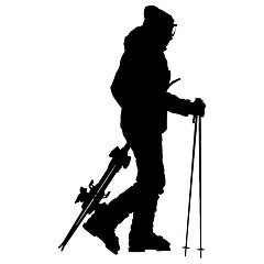 Image showing Skier standing on the snow and keeps skis. sport silhouette