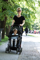 Image showing mother pushed her baby daughter in a stroller