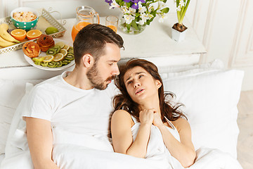 Image showing Young adult heterosexual couple lying on bed in bedroom