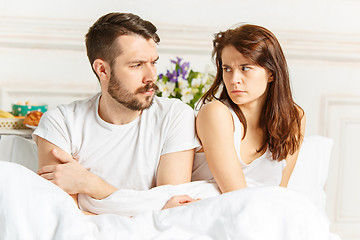 Image showing Young adult heterosexual couple lying on bed in bedroom