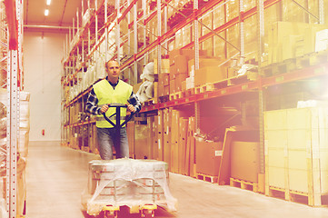 Image showing man carrying loader with goods at warehouse