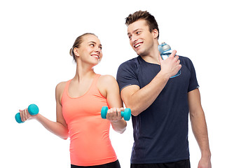 Image showing sportive man and woman with dumbbell and water