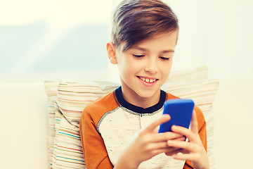 Image showing boy with smartphone texting or playing at home