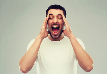 Image showing crazy shouting man in t-shirt over gray background