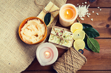Image showing close up of natural soap and candles on wood