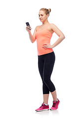 Image showing happy smiling sportive young woman with smartphone