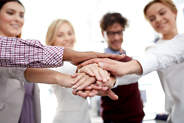 Image showing happy business team with hands on top at office