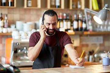 Image showing happy man or waiter at bar calling on smartphone