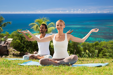 Image showing smiling couple making yoga exercises outdoors
