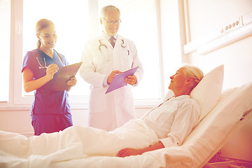 Image showing doctor and nurse visiting senior woman at hospital