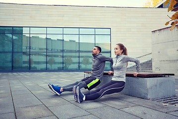 Image showing couple doing triceps dip exercise outdoors