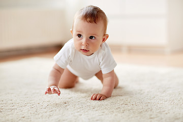 Image showing little baby in diaper crawling on floor at home