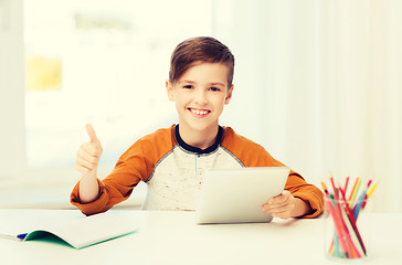 Image showing happy boy with tablet pc showing thumbs up at home