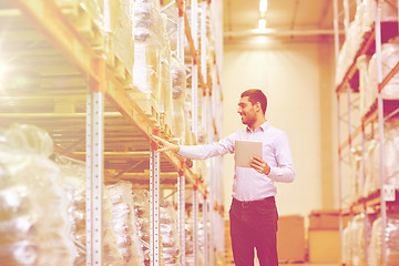 Image showing happy businessman with tablet pc at warehouse