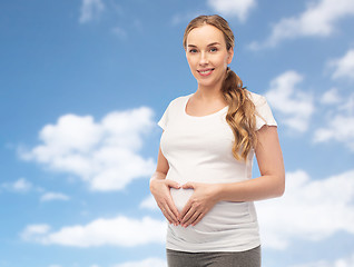 Image showing happy pregnant woman showing heart gesture